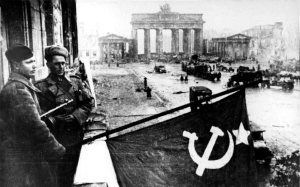 Bandeira soviética hasteada no Hotel Adlon, em Berlim. Ao fundo vê-se os Portões de Brandemburgo.