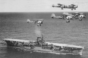HMS Ark Royal sendo sobrevoado por bombardeiros torpedeiros Swordfish.