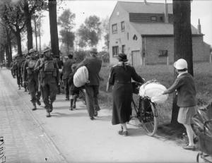 Soldados aliados cruzando-se com refugiados franceses durante a Batalha da França, Maio de 1940.